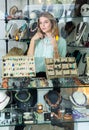 Girl behind glass trying on necklace from pink aventurine Royalty Free Stock Photo