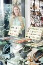 Girl behind glass trying on necklace from pink aventurine Royalty Free Stock Photo