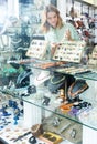 Girl behind glass trying on necklace from pink aventurine Royalty Free Stock Photo