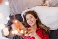 Interested girl with black manicure posing on her bed. Indoor overhead portrait of glad caucasian female model having