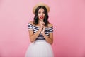 Interested glamorous woman in vintage summer attire standing on pink background. Photo of fascinati Royalty Free Stock Photo