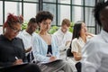 Interested happy young multiracial colleagues sitting on chairs, listening to male boss team leader Royalty Free Stock Photo