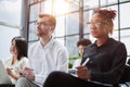 Interested happy young multiracial colleagues sitting on chairs, listening to male boss team leader Royalty Free Stock Photo