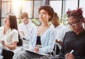 Interested happy young multiracial colleagues sitting on chairs, listening to male boss team leader Royalty Free Stock Photo