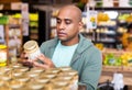 Interested Latin American reading product label on jar in supermarket