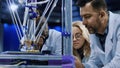 Researchers watching 3-D printing machine in process Royalty Free Stock Photo