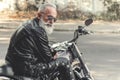 Interested old man ready for riding motorcycle Royalty Free Stock Photo