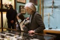 Preteen girl and elderly woman in protective masks viewing antique handguns in museum