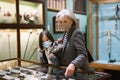 Preteen girl and elderly woman in protective masks viewing antique handguns in museum