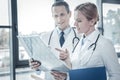 Interested responsible doctors examining the x-ray scan focusing on it. Royalty Free Stock Photo