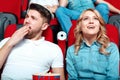 Interested woman and bored man in cinema Royalty Free Stock Photo