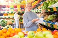 Interested woman choosing fresh romaine lettuce in supermarket Royalty Free Stock Photo