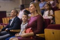 Interested woman theatergoer watching stage performance in theater Royalty Free Stock Photo