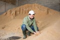 Farmer checking quality of soybean hulls for livestock feeding