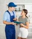 Young technician from cleaning company discussing order with female homeowner