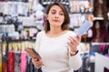 Interested young woman selecting comb for hair in shop