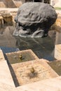 Armenia, Yerevan, September 2021. Side view of a stone head watching from the pool.