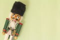 Interesting beautiful christmas nutcracker soldier on green colored paper surface texture with copy space Royalty Free Stock Photo