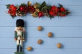 Interesting beautiful Christmas ornaments decorations with nutcracker soldier on blue colored wooden surface texture with copy spa Royalty Free Stock Photo