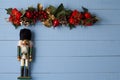 Interesting beautiful Christmas ornaments decorations with nutcracker soldier on blue colored wooden surface texture with copy spa Royalty Free Stock Photo