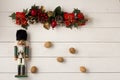 Interesting beautiful Christmas ornaments decorations with nutcracker soldier on white colored wooden surface texture with copy sp Royalty Free Stock Photo