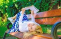 Interesting book. Lady smiling face enjoy rest. Girl reading outdoors while relaxing on bench. Girl lay bench park Royalty Free Stock Photo