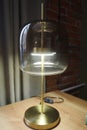 An interesting designer lamp on a golden base with thick glass. English style. Classic interior