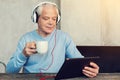 Progressive pensioner watching film on his tablet Royalty Free Stock Photo