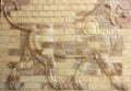 interesting image in earth tones of a lion carved in high relief on a brick wall