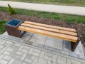 Interesting, new park bench with trash. Made of wood and rusty metal