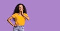 Interesting Offer. Pensive Asian Girl Looking Aside At Copy Space Over Purple Background And Playfully Smiling, Panorama