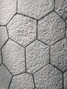 Interesting pattern of hexagonal shaped white bricks on the wall or floor, made of rock stone with contemporary style of uneven
