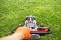 The interesting point of view from a man pushing a lawn mower. Lawn mower mowing green grass Royalty Free Stock Photo