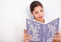 An interesting read...Cropped studio shot of an attractive young woman looking through a book. Royalty Free Stock Photo