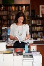 This is an interesting read. A young woman leafing through the pages of a book in a bookshop. Royalty Free Stock Photo