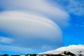 interesting shaped clouds, snowy volcanic mountain in a sunny day