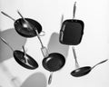 Interesting shot of trendy black kitchen utensils dancing on white background Royalty Free Stock Photo