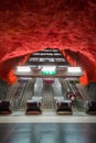 Interesting Stockholm subway escalators. Left uncovered stone surface in tunnel. Red painted jagged stone
