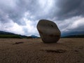 Interesting structured stone on the sand under a cloudy sky Royalty Free Stock Photo