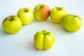 An interesting, unusual, strange apple. An ugly apple surrounded by ordinary ones. The photo symbolizes individuality , leadership
