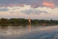 Yaroslavl region, Russia, July 8, 2023. A dilapidated bell tower on the river bank at sunset.