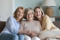 Elderly granny, mature daughter, millennial granddaughter smile pose for camera Royalty Free Stock Photo