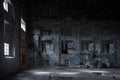 Interior of abandoned factory with stained concrete walls, bricked windows and pieces of old equipment Royalty Free Stock Photo