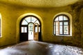 Interior of an abandoned Soviet-era house, yellow walls, parquet and large windows Royalty Free Stock Photo