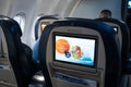 The interior of the aircraft. Empty airplane cabin. Rows of passenger seats with screens in the head restraints