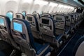 The interior of the aircraft. Empty airplane cabin. Rows of passenger seats with screens in the head restraints Royalty Free Stock Photo