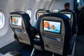 The interior of the aircraft. Empty airplane cabin. Rows of passenger seats with screens in the head restraints