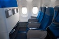 The interior of the aircraft. Empty airplane cabin. Rows of passenger seats with screens in the head restraints