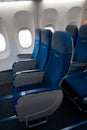 The interior of the aircraft. Empty airplane cabin. Rows of passenger seats with screens in the head restraints