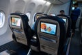 The interior of the aircraft. Empty airplane cabin. Rows of passenger seats with screens in the head restraints Royalty Free Stock Photo